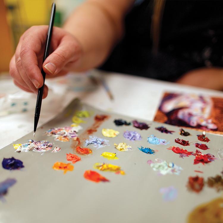 A close up view of a paint palette and brush.